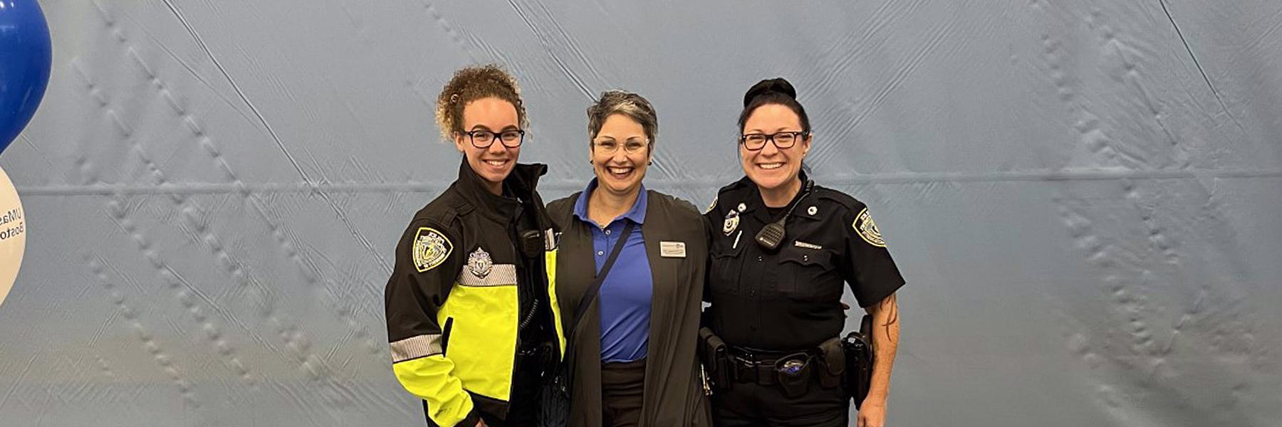 3 security offers pose at an information table indoors.